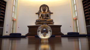 A large Buddha statue with a crystal ball